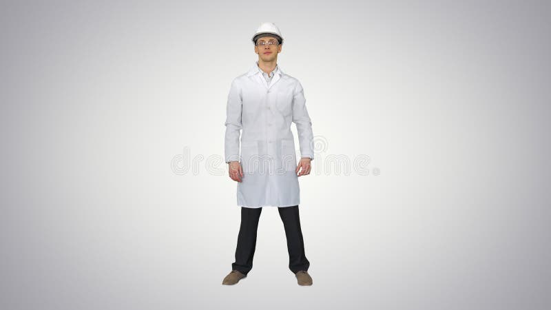 Wetenschapper ingenieur in white robe safety helm en bril die grappige bewegingen maakt met zijn ogen aan het eind op gradiënt