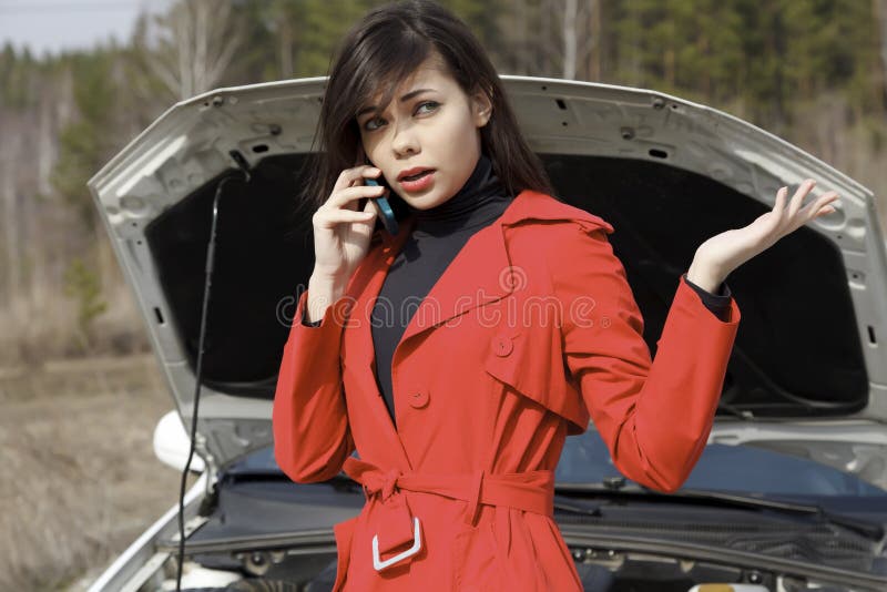 Young woman standing by her damaged car and calling for help. Young woman standing by her damaged car and calling for help