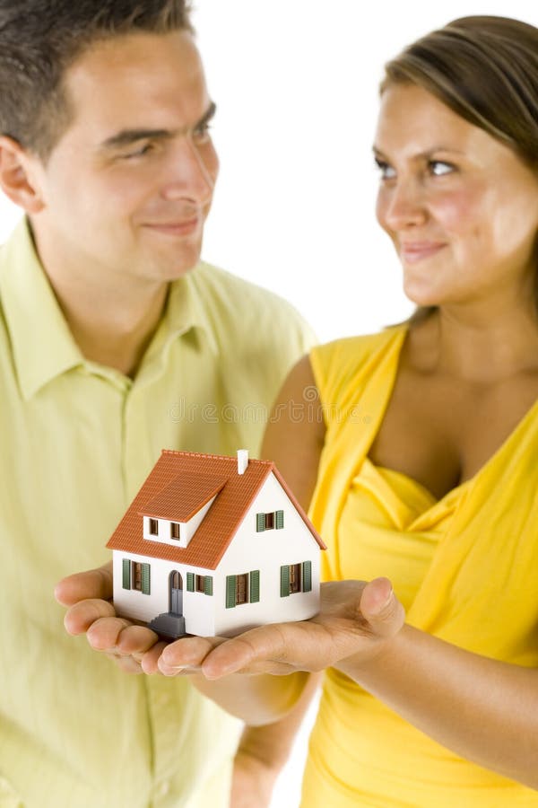 Mladý, šťastný pár, který drží dům miniaturní.