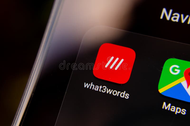 What3words app icon on the smartphone screen in the section of navigation apps, next to Google Maps. What 3 words is an innovative royalty free stock photography