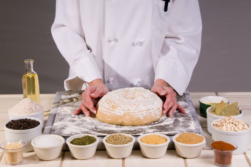 Close up of a uniformed female Chef holding her multi-grained wheat bread dough ready for baking. Close up of a uniformed female Chef holding her multi-grained wheat bread dough ready for baking.