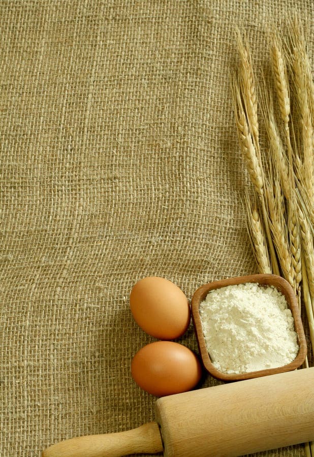 Wheat ears, flour and eggs on sacking.