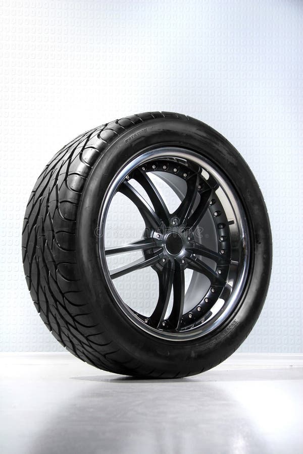 Wheel of a car on a background of white walls royalty free stock photo