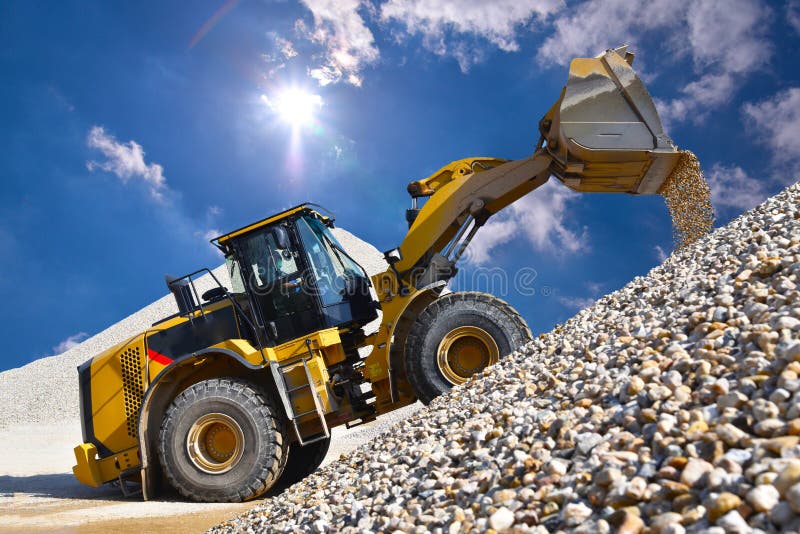 Wheel loader in a gravel pit during mining - heavy construction machine in open cast mining