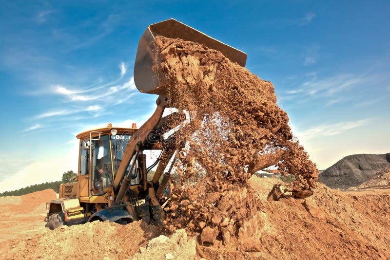 Wheel loader unloading soil at construction site stock image