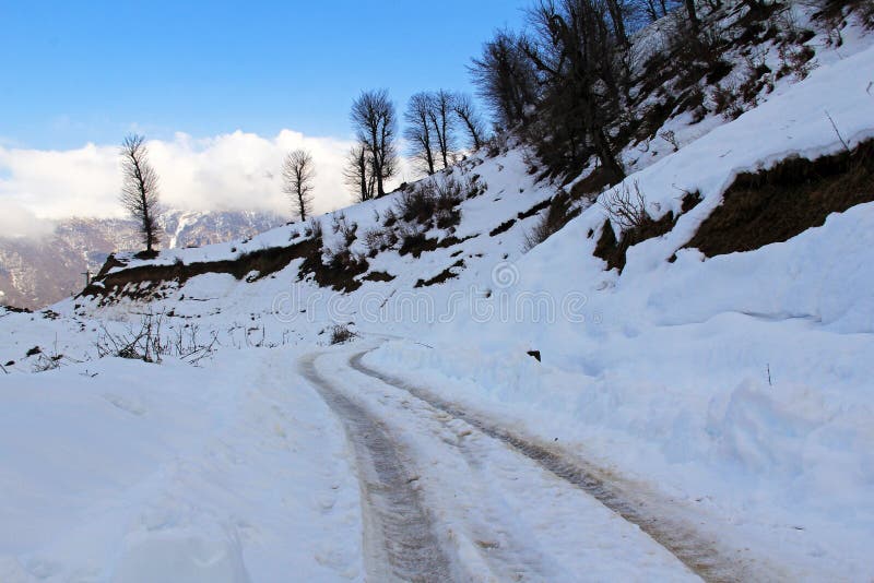 Wheel track on snow covered mountain road