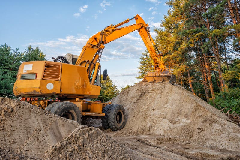 Wheeled excavator working on a construction site. Track hoe construction excavator stock images, royalty-free photos and pictures