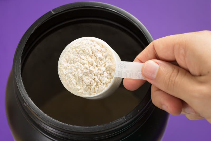 Whey Protein Powder in measuring scoop. Stock Photo