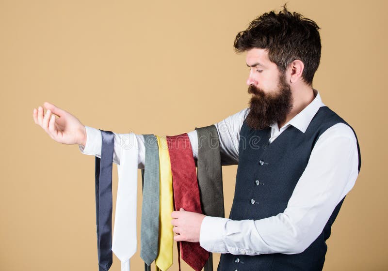 Which one is matching his clothing style. Bearded man choosing the right necktie for business life style. Businessman in classic style. Brutal hipster wearing formal style holding collection of ties.