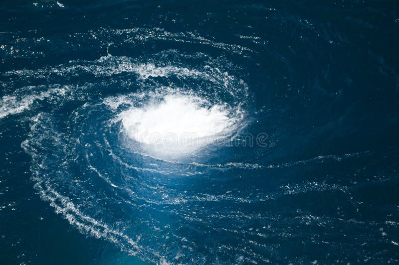 A blue water vortex that funnels below the surface. Whirlpool vortex water stock images, royalty-free photos and pictures
