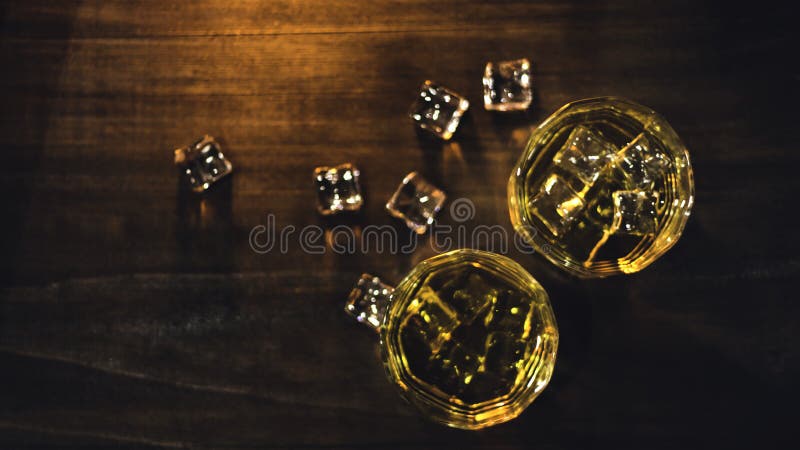 Whiskey de vue supérieure en verre avec de la belle glace ambre, placée sur une table en bois avec une surface approximative sur photographie stock libre de droits Whiskey de vue supérieure en verre avec de la belle glace ambre, placée sur une table en bois avec une surface approximative sur photographie stock libre de droits