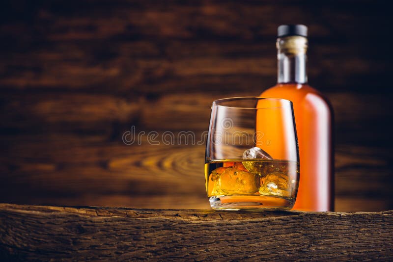 Whiskey glass and bottle on the old table