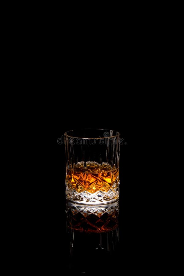 Splash of whiskey from an ice cube in glass Stock Photo by Alexlukin