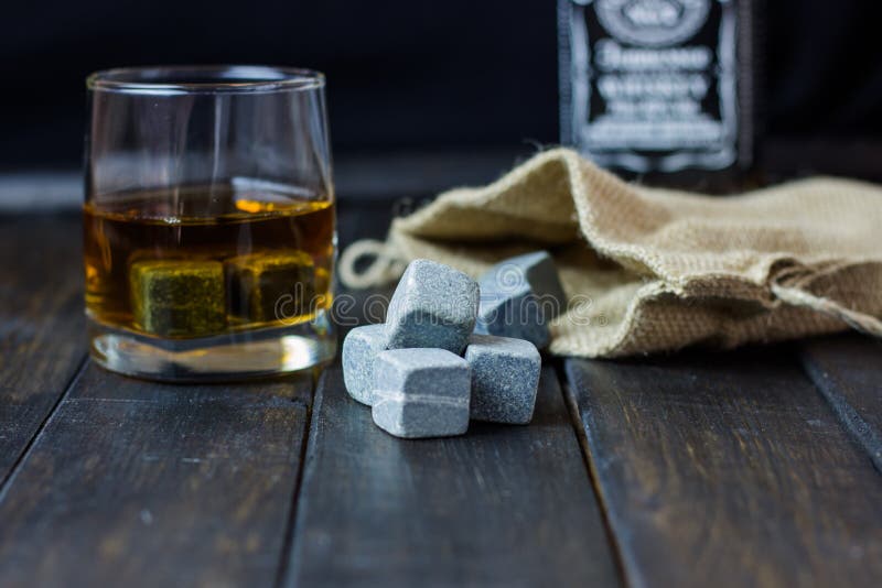 Whiskey in a Glass with Stones for Cooling Drinks on a Wooden Table