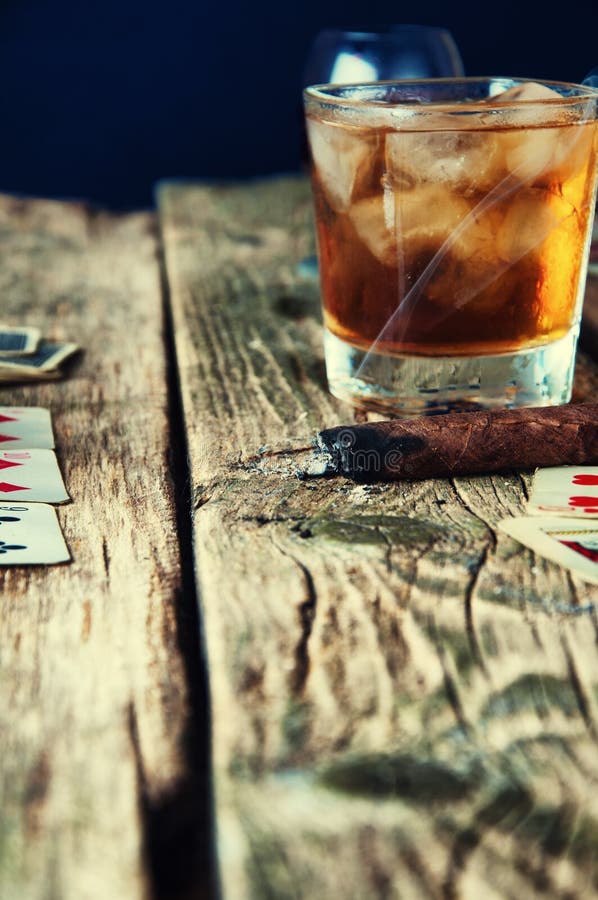 Whiskey, sigaro e carte su un fondo di legno fotografie stock libere da diritti