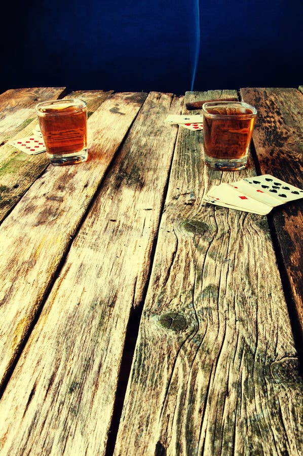 Whiskey, sigaro e carte su un fondo di legno fotografia stock