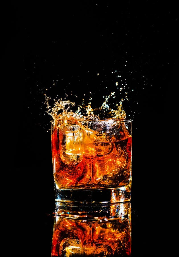 Whiskey with Splash on Black Background, Brandy in a Glass Stock Image