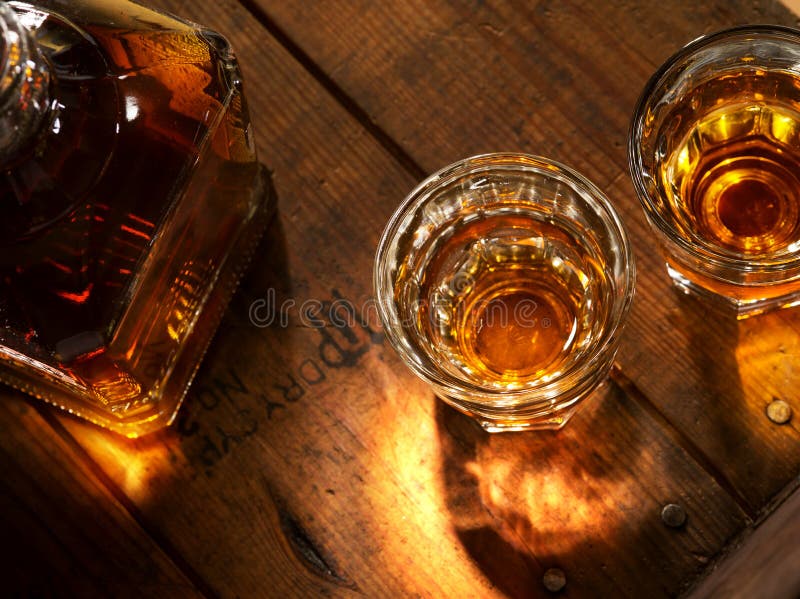 Close up view of nice bottle and two glasses filled with whiskey. Close up view of nice bottle and two glasses filled with whiskey
