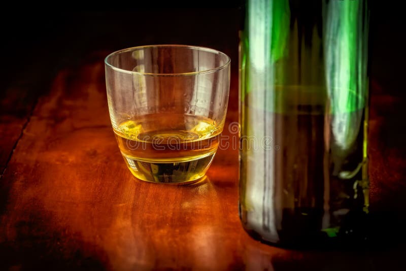 Whisky or rum and a green liquor bottle