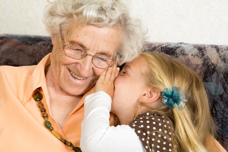 A little girl with is whispering with her great-grandmother. Old granny stock images, royalty-free photos and pictures