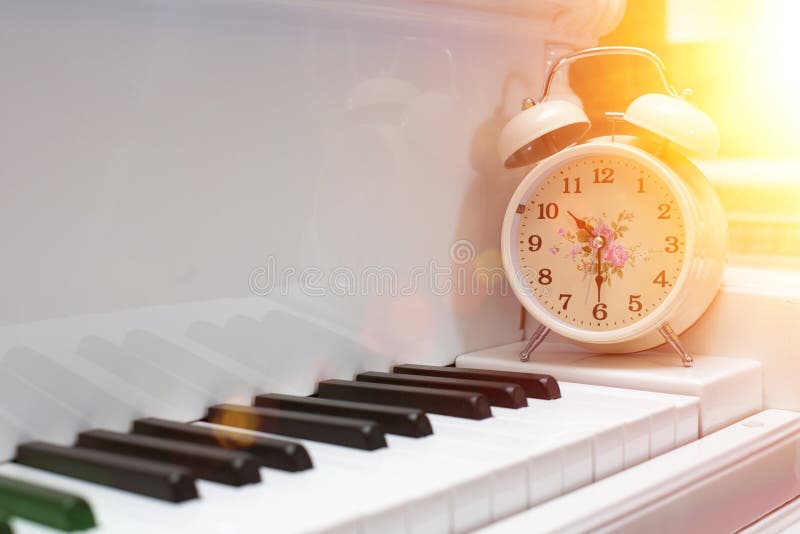 Piano and Alarm Clock, the Time To Practice the Piano. Stock Photo