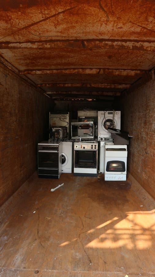 White appliances inside a container for the collection of electrical waste stock images