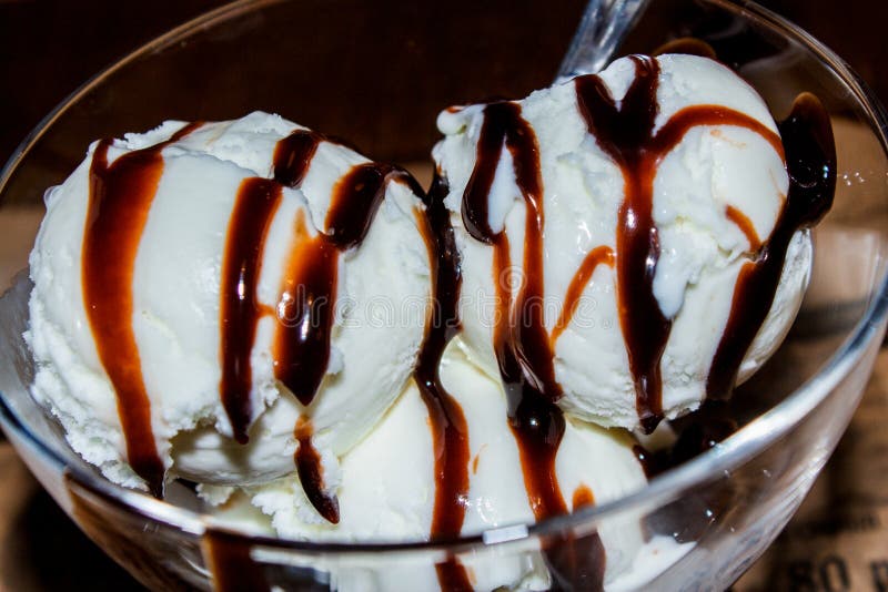 White Ball of Ice Cream Watered with Chocolate Icing Stock Photo