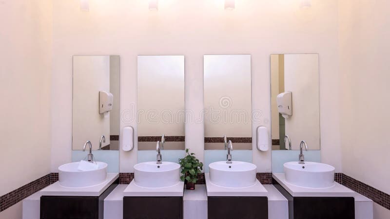 white basins in bathroom interior with granitic tiles