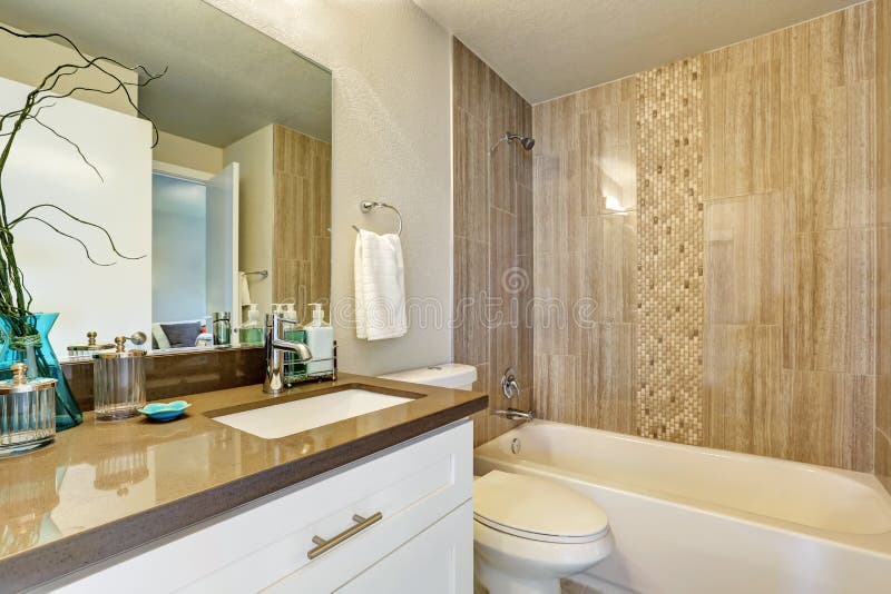 White bathroom with gray and brown tile wall trim stock photography
