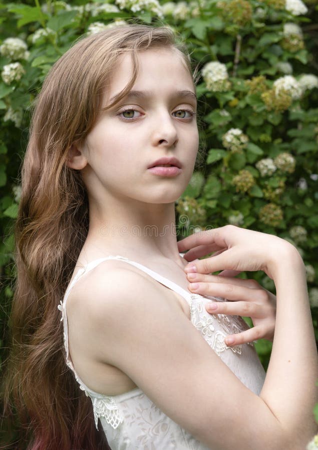 1 Beautiful White Girl 11 Years Old Near a White Flowering Bush