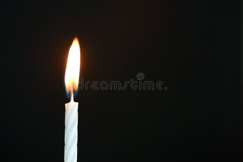 The white birthday candle against a dark background