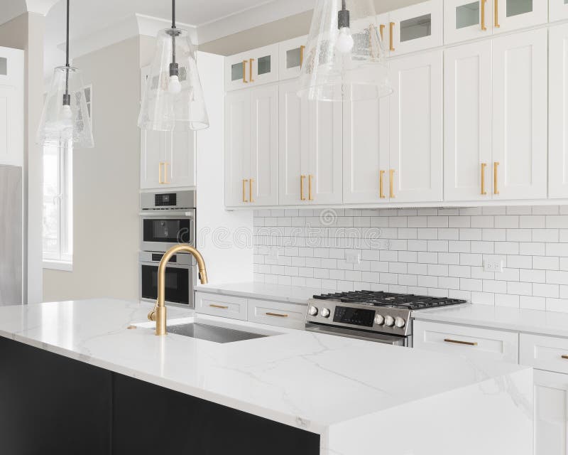 A White and Black Kitchen with Gold Accents and Subway Tile Backsplash