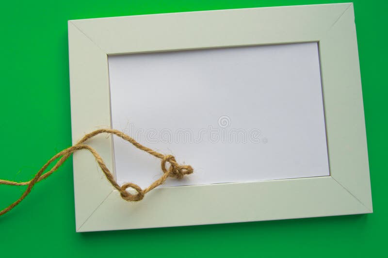 White blank frame with space for text lies on a green background, decorated with twine in knots, celebrating St. Patrick`s Day stock photography White blank frame with space for text lies on a green background, decorated with twine in knots, celebrating St. Patrick`s Day stock photography