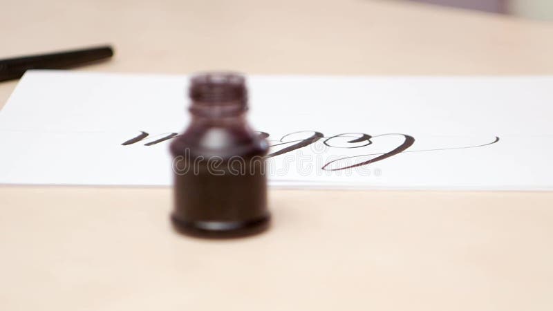 White blank with written letters on beige desk. Close shot. Side view. Camera moves along the beige desk. Calligraphic