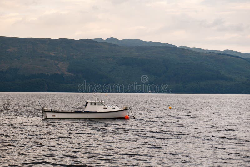 A white boat at Loch Lomond lake in Scotland at typical cloudy Scottish weather. A white boat at Loch Lomond lake in Scotland at typical cloudy overcast Scottish stock images A white boat at Loch Lomond lake in Scotland at typical cloudy Scottish weather. A white boat at Loch Lomond lake in Scotland at typical cloudy overcast Scottish stock images