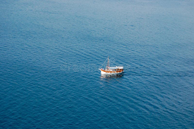 White boat moving on blue tranquil sea from above stock images