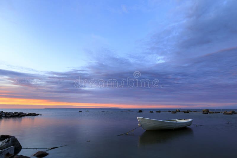 White boat in sea at sunset