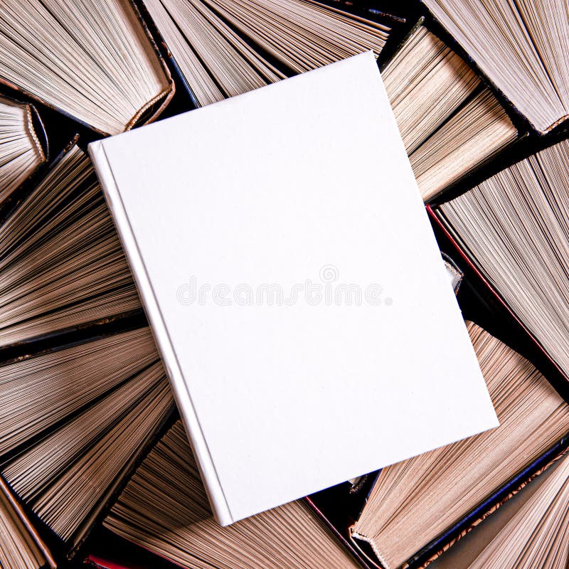 White book in white cover with a place for text lies on multicolored old open books