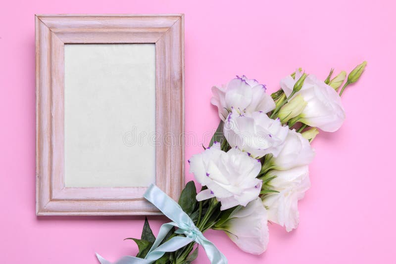 White bouquet of eustoma with frame for photo on a bright pink background top view royalty free stock photography