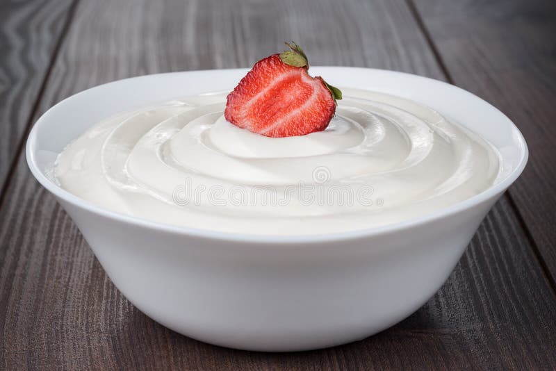 White bowl full of sour cream with strawberry