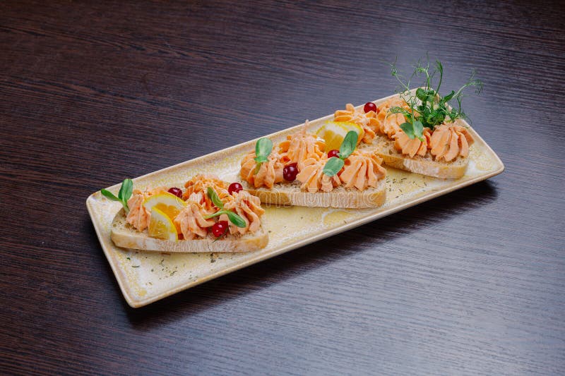 White Bread Sandwiches with Fish Cream and Herbs on a White Plate. Appetizer for Wine Stock