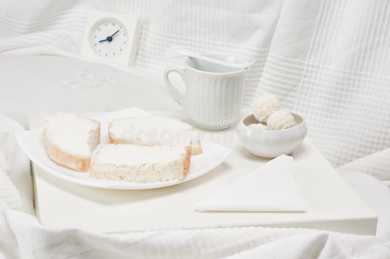 Vassoio con la colazione su un letto bianco.