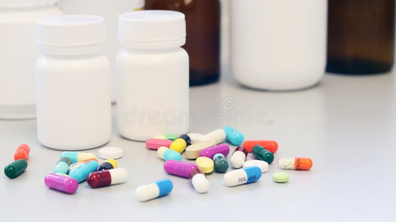 White and Brown glass medicine bottles with colorful tablets, pills, capsules drugs using for treatment and cure the disease. White and Brown glass medicine royalty free stock image White and Brown glass medicine bottles with colorful tablets, pills, capsules drugs using for treatment and cure the disease. White and Brown glass medicine royalty free stock image