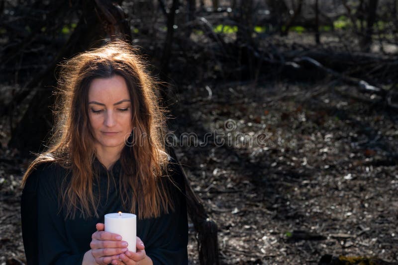 White burning Candle in woman`s hands in the middle of the forest. Hope and Pray concept. All Saints Day celebration. Witchcraft royalty free stock photography White burning Candle in woman`s hands in the middle of the forest. Hope and Pray concept. All Saints Day celebration. Witchcraft royalty free stock photography