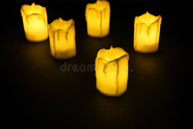 White Candle on Black Background Isolated. Set of Candle.Small Candle with Light Yellow Spots on