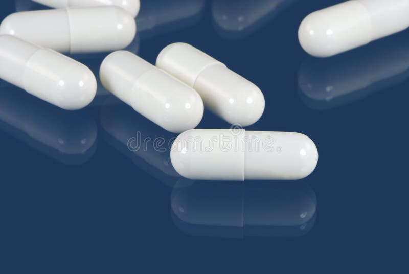 Top View of Many White Medication Capsules or Pills and One Blue Color