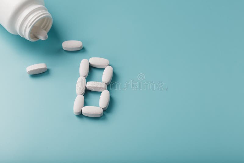 White Capsules with Vitamins in the Form of B Poured from a Jar on a
