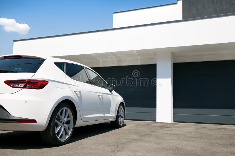 White car in front of modern house with garage door