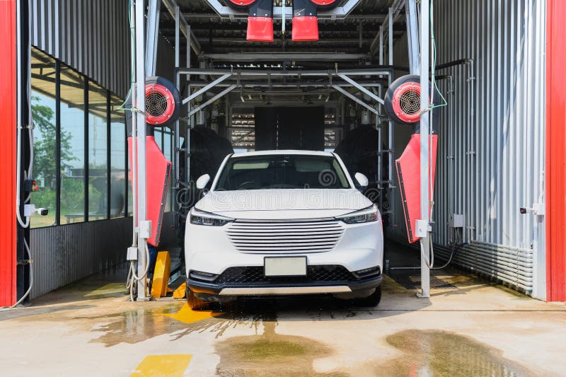 Car Wash Automatic, Red Rotating Brushes, Water Spray Stock Photo