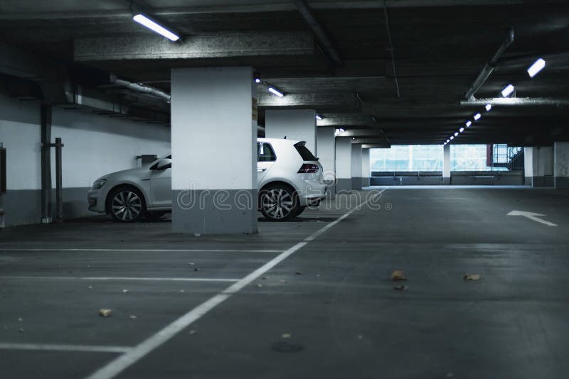 White car parked in empty parking garage.